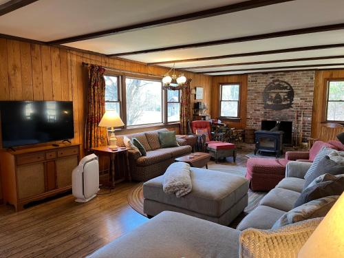 JohnsburgにあるHannah's Birch Farm 10 Min to Gore Ski Mt.のソファとテレビのあるリビングルーム