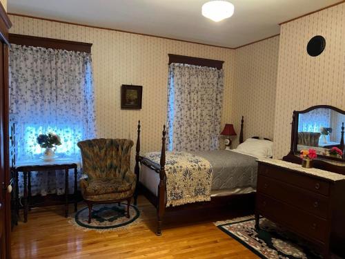 ein Schlafzimmer mit einem Bett, einem Stuhl und einem Spiegel in der Unterkunft Brooksbnb in Sussex