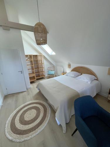 une chambre avec un grand lit et une chaise bleue dans l'établissement villa Armen, à Carnac