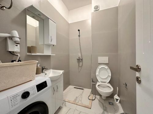 a white bathroom with a toilet and a sink at Sublime studio nr3 in Ulcinj