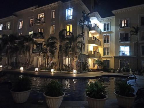 a building with a pool in front of it at night at Ronnie's Studio Apartment in Arpora