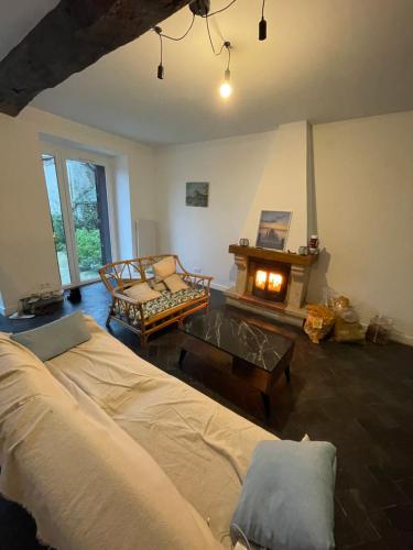 - un salon avec un lit et une cheminée dans l'établissement Maison Normandie Bretagne, à Saint-James