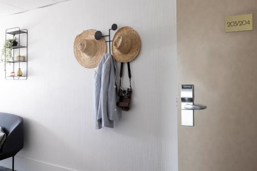 a clock on a wall with a hat on it at Best Western Plus Hotel les Rives du Ter in Larmor-Plage