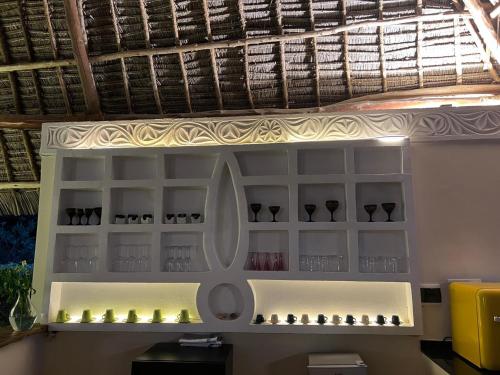 a shelf with wine glasses on a wall at Maharaja Boutique Hotel Zanzibar in Uroa