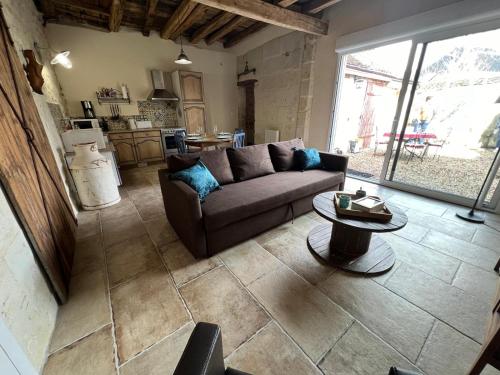 una sala de estar con un sofá y una mesa en L'étable endormie*5 min Beauval, en Saint-Aignan