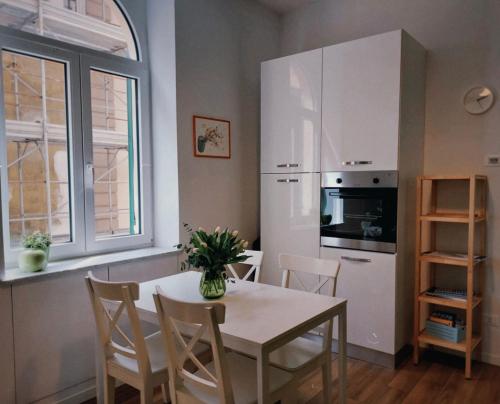 una cucina con un tavolo e un frigorifero bianco di Le Casette a La Spezia