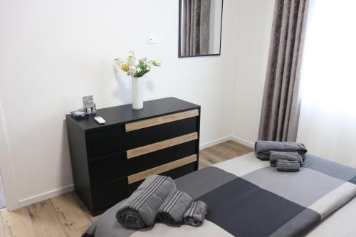 a bedroom with a bed and a dresser with a vase at DolceVita apartment in Como