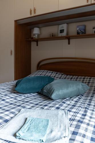 a bed with two blue pillows on it at Appartamento vista Grigna, Natura,sport e relax in Primaluna