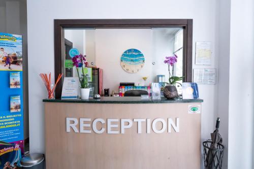 a reception desk in a room with a mirror at Residence Marconi Mare in Rimini