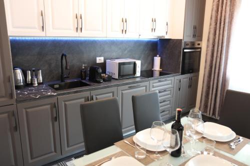 a kitchen with a table with wine glasses and a microwave at DolceVita apartment in Como