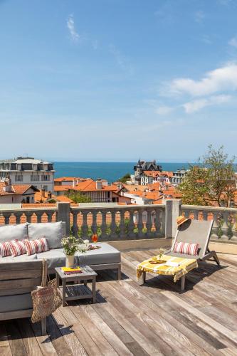 a patio with a couch and chairs on a deck at Hotel de Silhouette in Biarritz
