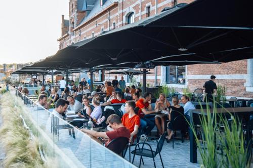 a group of people sitting at an outdoor restaurant at Van der Valk Hotel Mechelen in Mechelen
