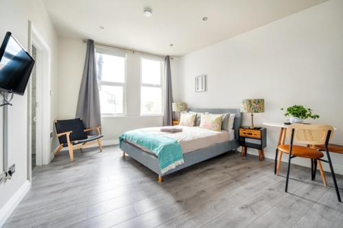 ロンドンにあるCity studios londonのベッドと机とテレビのある寝室