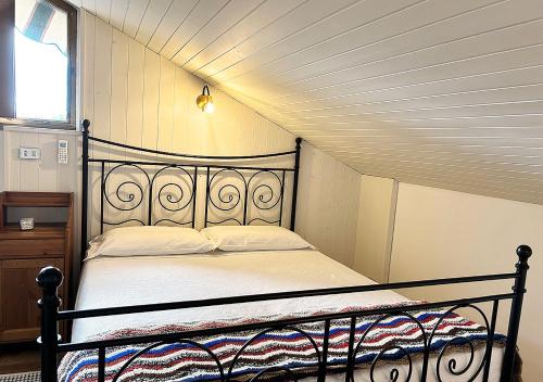 a bedroom with a black bed in a attic at La mansardina in Venegono Superiore