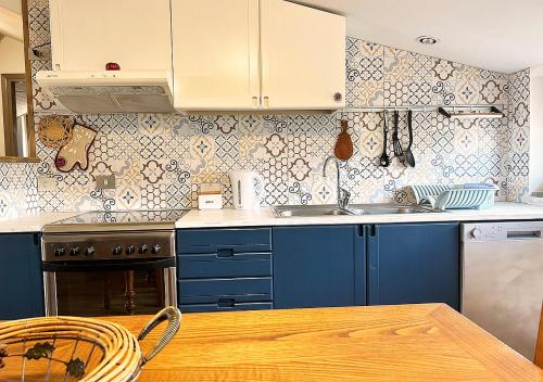 a kitchen with blue cabinets and a wooden table at La mansardina in Venegono Superiore