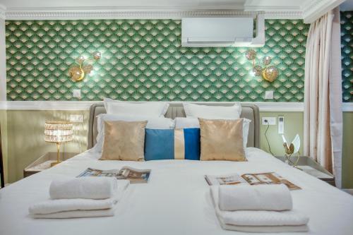une chambre avec un grand lit blanc avec des serviettes dessus dans l'établissement Elegant Triplex in Paris - Ideal for 10 - Aircon, à Paris