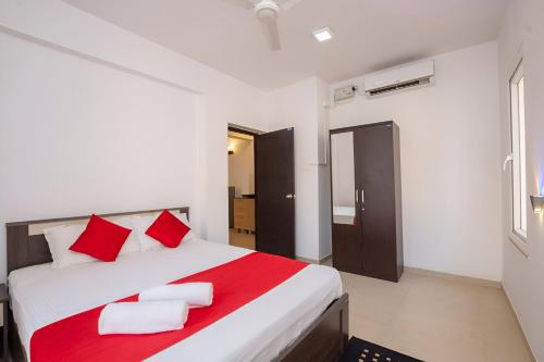a bedroom with a bed with red and white pillows at Ronnie's Studio Apartment in Arpora