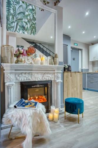un salon avec une cheminée et une chaise bleue dans l'établissement Elegant Triplex in Paris - Ideal for 10 - Aircon, à Paris