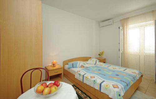 a bedroom with a bed and a bowl of fruit on a table at White Hill Studio-Apartments in Makarska