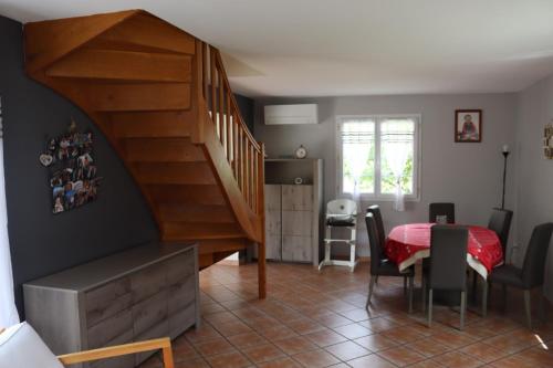 une pièce avec un escalier, une table et des chaises dans l'établissement Maison de famille à la campagne proche de disneyland et paris, à Varinfroy