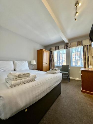 a bedroom with a large bed with towels on it at Hotel Coco in Felixstowe