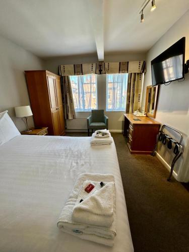 a hotel room with a bed with towels on it at Hotel Coco in Felixstowe