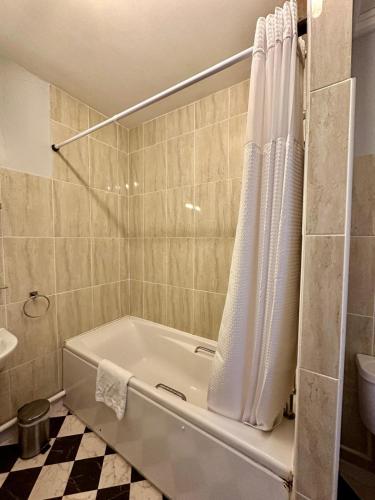 a bathroom with a bath tub and a toilet at Hotel Coco in Felixstowe