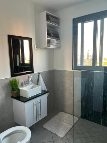 a bathroom with a sink and a toilet at Coastal Beach Apartments in Maputo