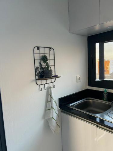 a kitchen with a sink and a shelf on the wall at Coastal Beach Apartments in Maputo