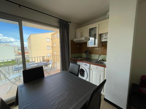 Il dispose d'un balcon et d'une cuisine avec une table et des chaises. dans l'établissement Agréable Studio Cabine avec place de Parking privatif, au Cap d'Agde