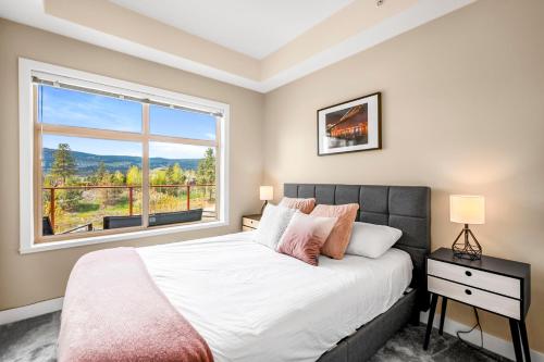 ein Schlafzimmer mit einem Bett und einem großen Fenster in der Unterkunft Top Floor Apartment at Amenity Rich Resort 406 in West Kelowna