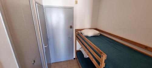 Cette petite chambre comprend des lits superposés et un placard. dans l'établissement Agréable Studio Cabine avec place de Parking privatif, au Cap d'Agde
