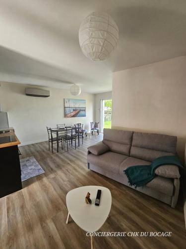 un salon avec un canapé et une table dans l'établissement Le Petit Ecureuil charmant gîte jardin terrasse, aux Herbiers