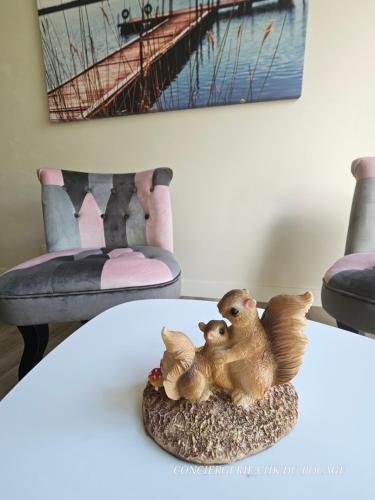una figura de dos patos sentados en una mesa en Le Petit Ecureuil charmant gîte jardin terrasse, en Les Herbiers