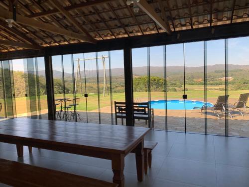 a room with a table and a view of a pool at Casa vista da serra in São João del Rei