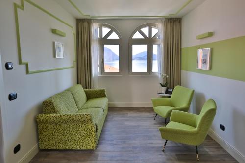 a waiting room with green chairs and a window at Hotel Al Campanile - Luxury Suites & Apartments in Baveno