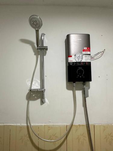 a shower with a fan attached to a wall at Nice Beach Bungalow in Koh Rong Island
