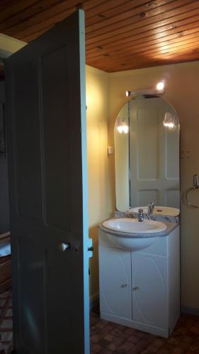 une salle de bain avec un lavabo et un miroir dans l'établissement La Fontaine, à Sahune