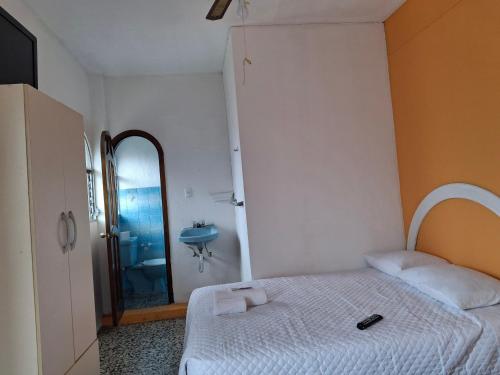 Un dormitorio con una cama, un lavabo y un espejo. en La Tía, en Jalapa