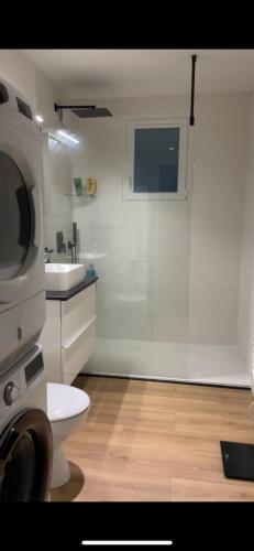 a bathroom with a toilet and a sink and a microwave at Havre du Golf - Joli T2 neuf in Seilh