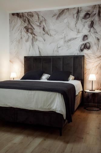 a bedroom with a bed and a wall with flowers at Apartments Petra in Risika