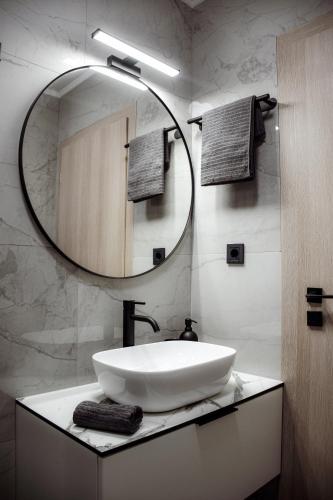 a bathroom with a sink and a large mirror at Apartments Petra in Risika