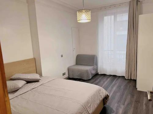 une chambre avec un lit, une chaise et une fenêtre dans l'établissement Appartement Rénové de 3 Pièces à Paris Nation, à Paris