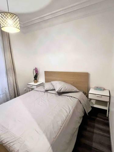 - une chambre avec un lit blanc et 2 tables de chevet dans l'établissement Appartement Rénové de 3 Pièces à Paris Nation, à Paris