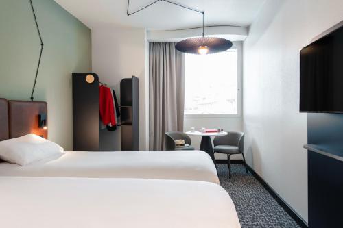a hotel room with a bed and a table at ibis Lausanne Centre in Lausanne