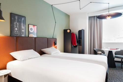 a hotel room with a large bed and a desk at ibis Lausanne Centre in Lausanne