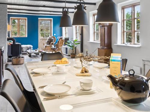 a dining room with a table with a tea kettle at Holiday Home Hughlek - 1-5km from the sea by Interhome in Gedser