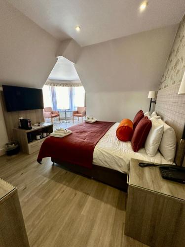 a hotel room with a large bed with red pillows at Hotel Coco in Felixstowe