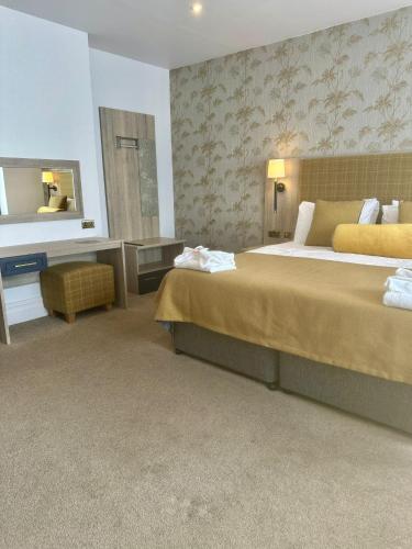a hotel room with a large bed and a mirror at Hotel Coco in Felixstowe