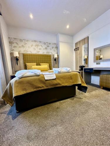 a large bedroom with a large bed and a fireplace at Hotel Coco in Felixstowe